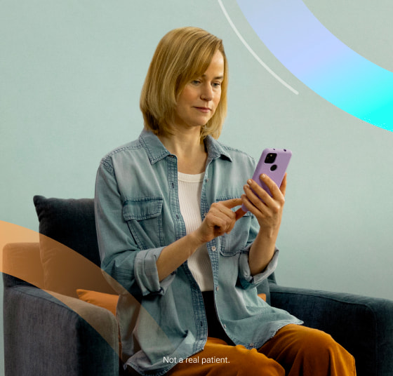 Woman sitting on a chair using Rejoyn on her smartphone